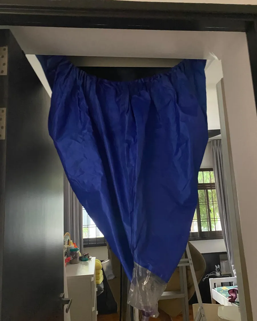 Blue aircon service cradle hanging across a bedroom doorway in a Singapore home