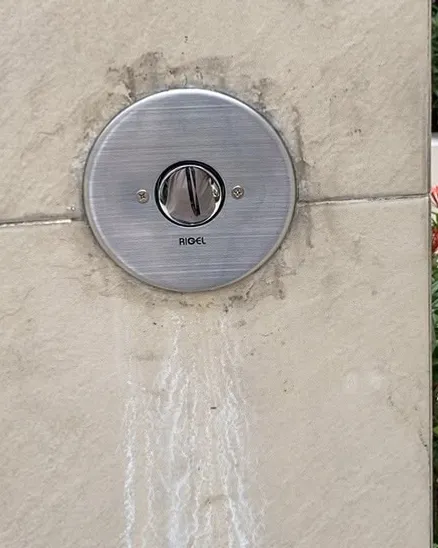 New stainless push-button shower valve installed on a tiled outdoor wall in Singapore