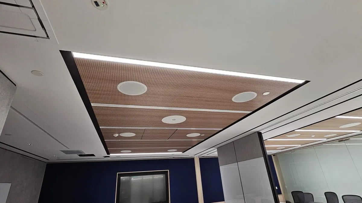 Timber slat ceiling panel with linear lighting and recessed speakers in a Singapore office