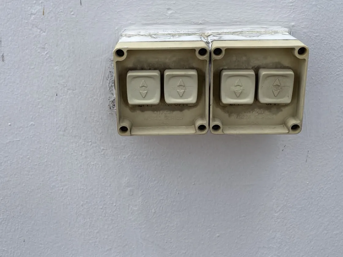 Pair of weatherproof surface-mounted switch boxes installed on an exterior wall in Singapore
